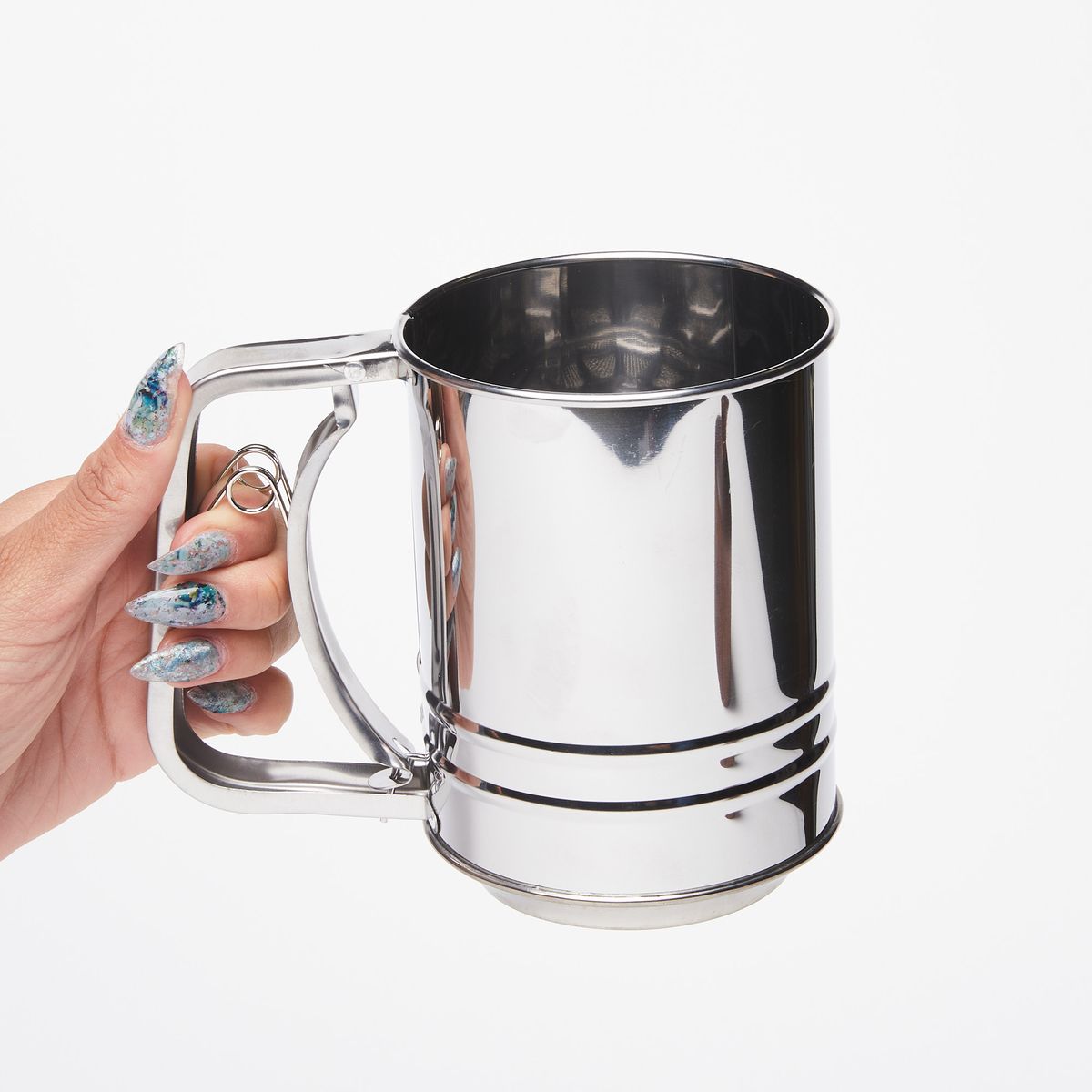 Hand holding a shiny metal flour sifter