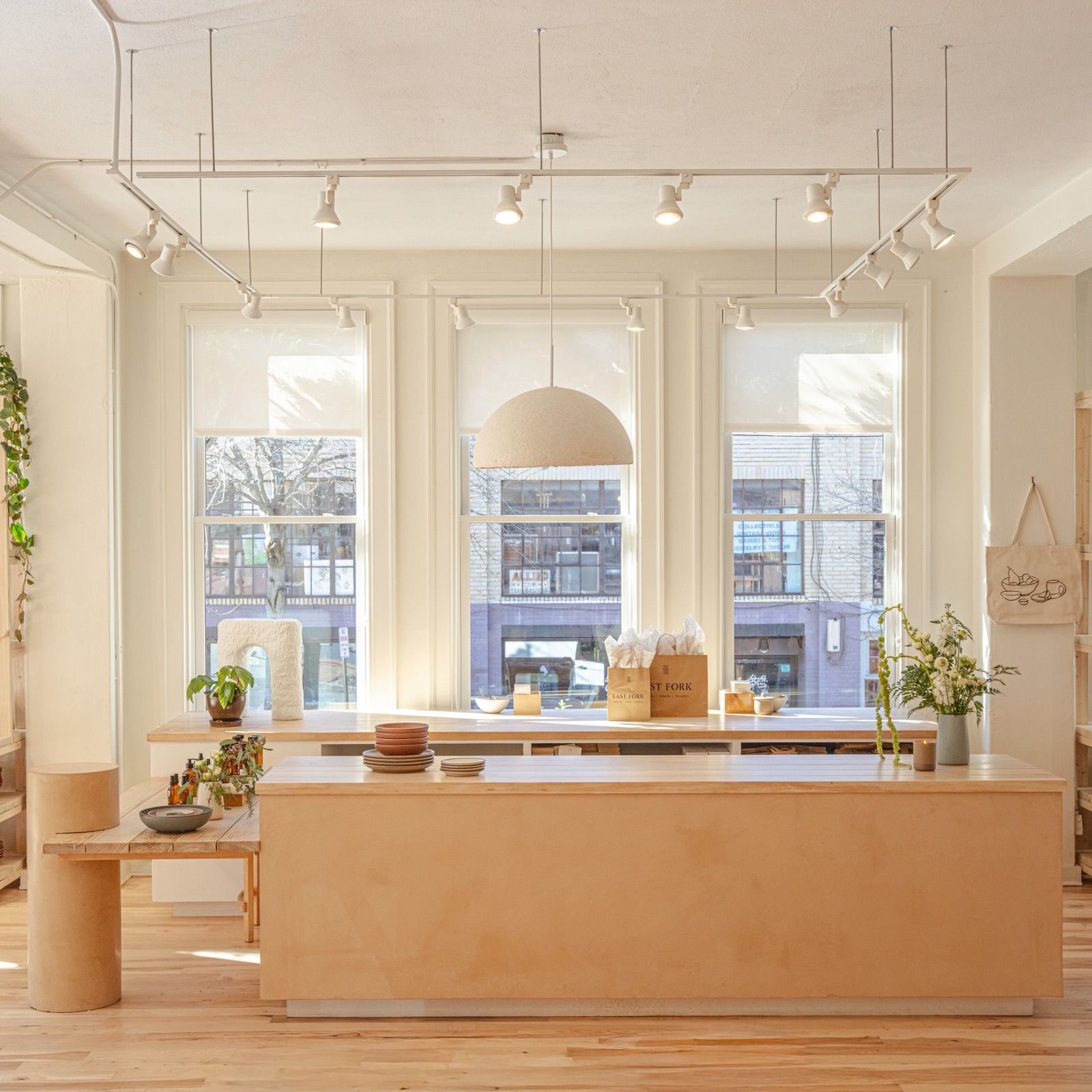An inside look at East Fork Asheville, large wooden cash wrap with large windows facing the street behind.