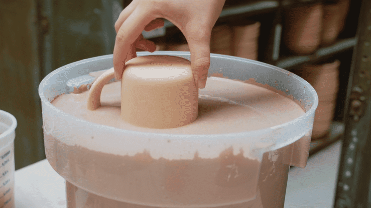 Dipping Mugs into glaze