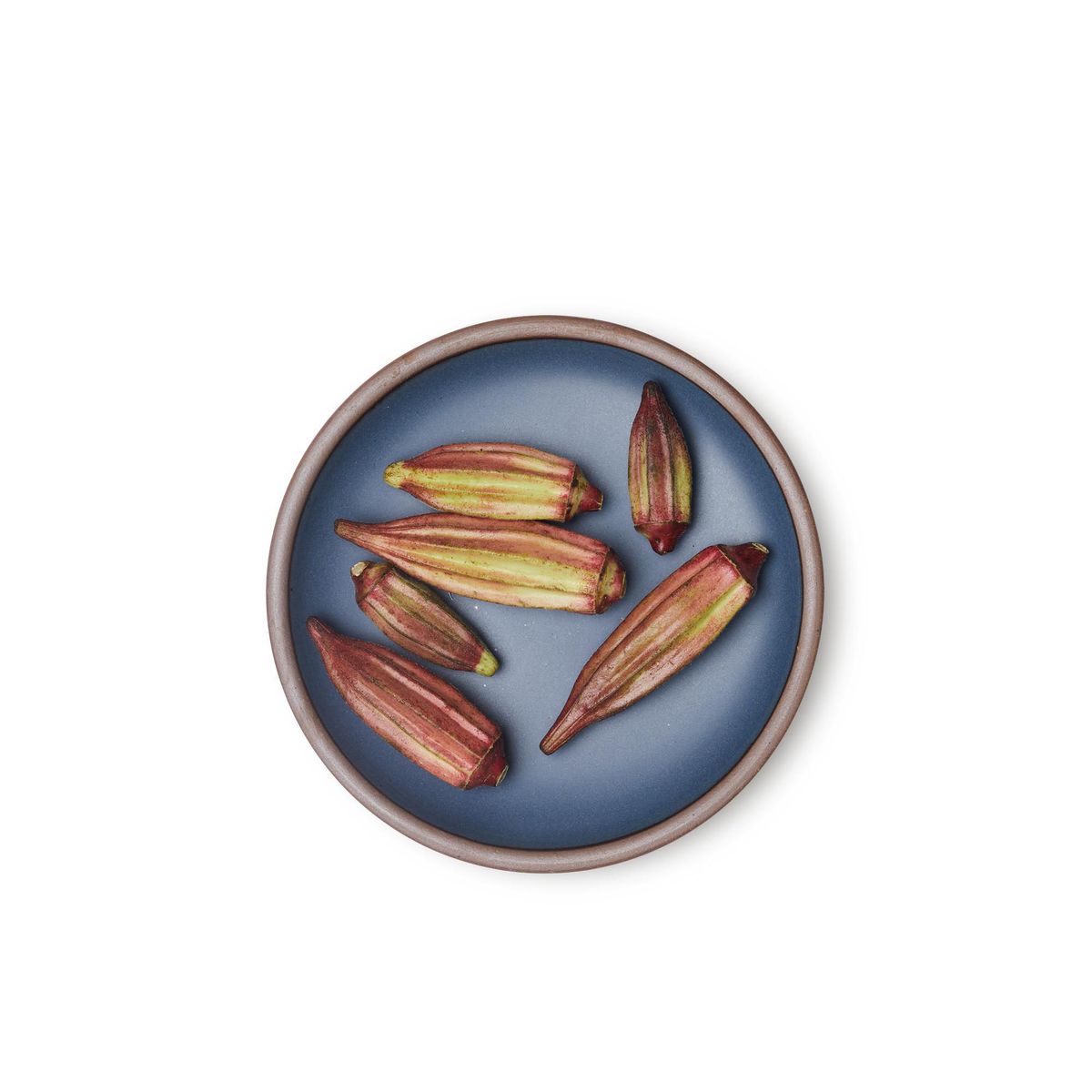 Okra on a medium sized ceramic plate in a toned-down navy color featuring iron speckles and an unglazed rim.
