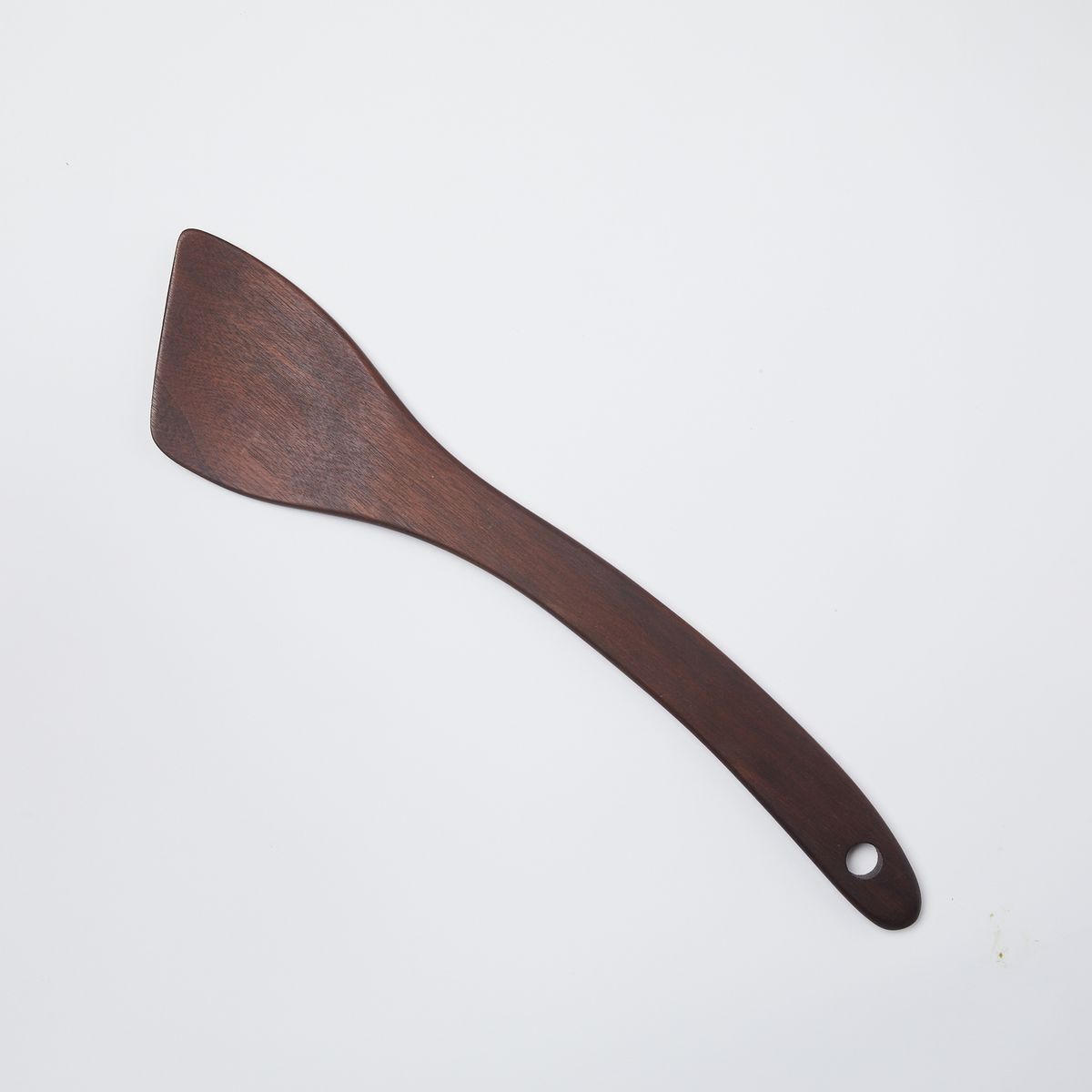 Black walnut wood spatula with a slanted head and a hole at the bottom 