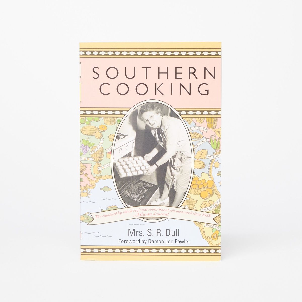Cover of a cookbook with yellow, brown, and pink stripes that reads "Southern Cooking" with a photo of a person holding a sheet pan near an open oven