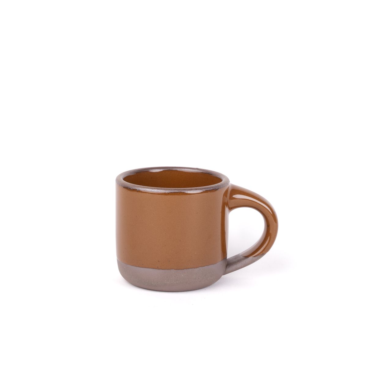 A small sized ceramic mug with handle in a glossy caramel brown glaze featuring iron speckles and unglazed rim and bottom base.