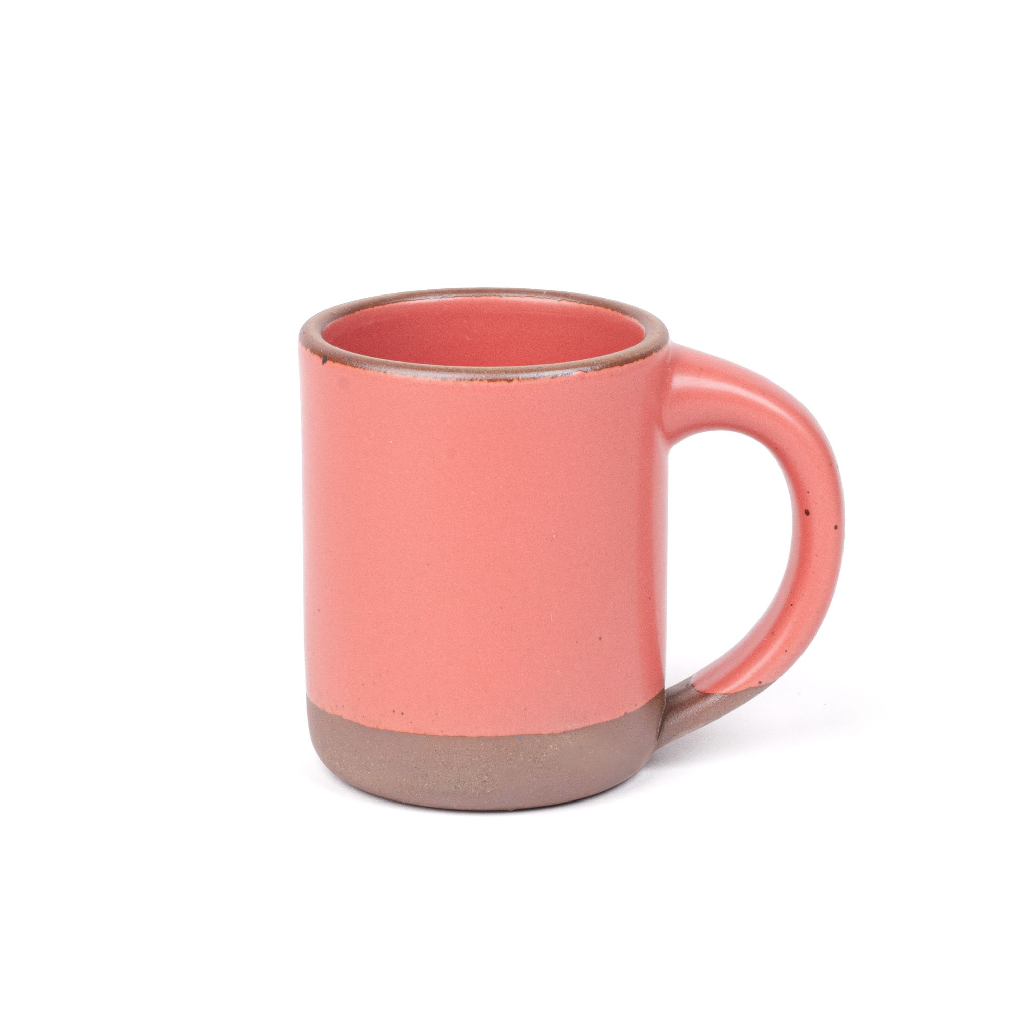 A big sized ceramic mug with handle in a watermelon pink color featuring iron speckles and unglazed rim and bottom base.