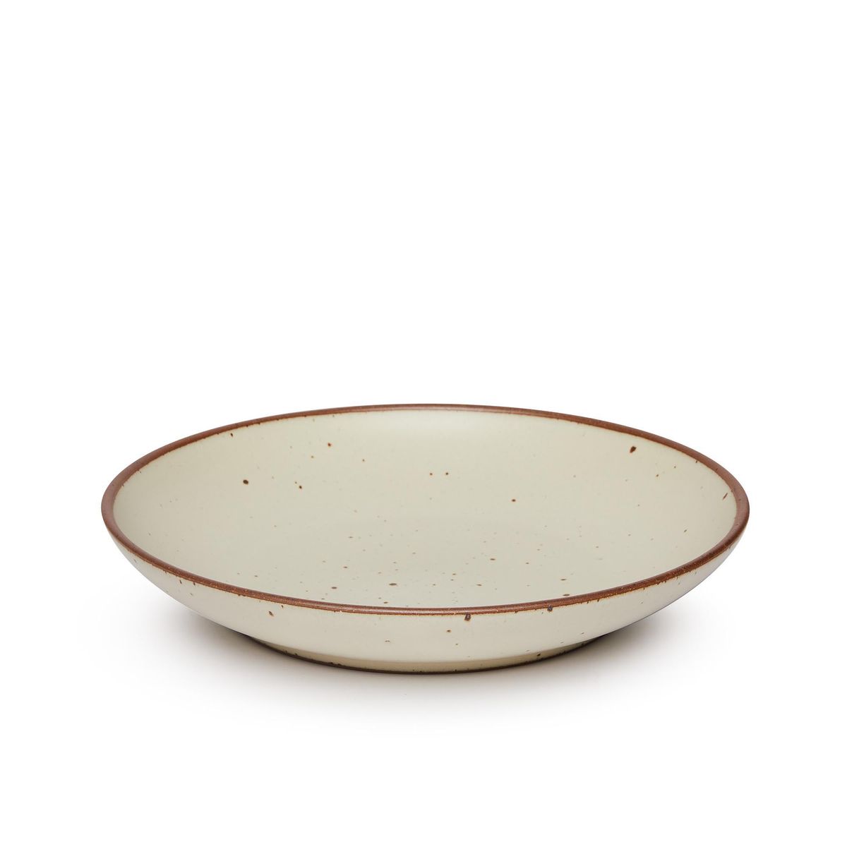 A large ceramic plate with a curved bowl edge in a warm, tan-toned, off-white color featuring iron speckles and an unglazed rim.