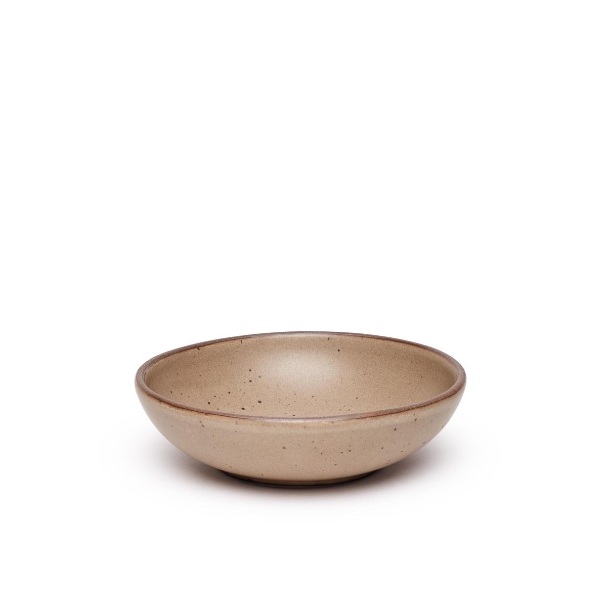 A dinner-sized shallow ceramic bowl in a warm pale brown color featuring iron speckles and an unglazed rim