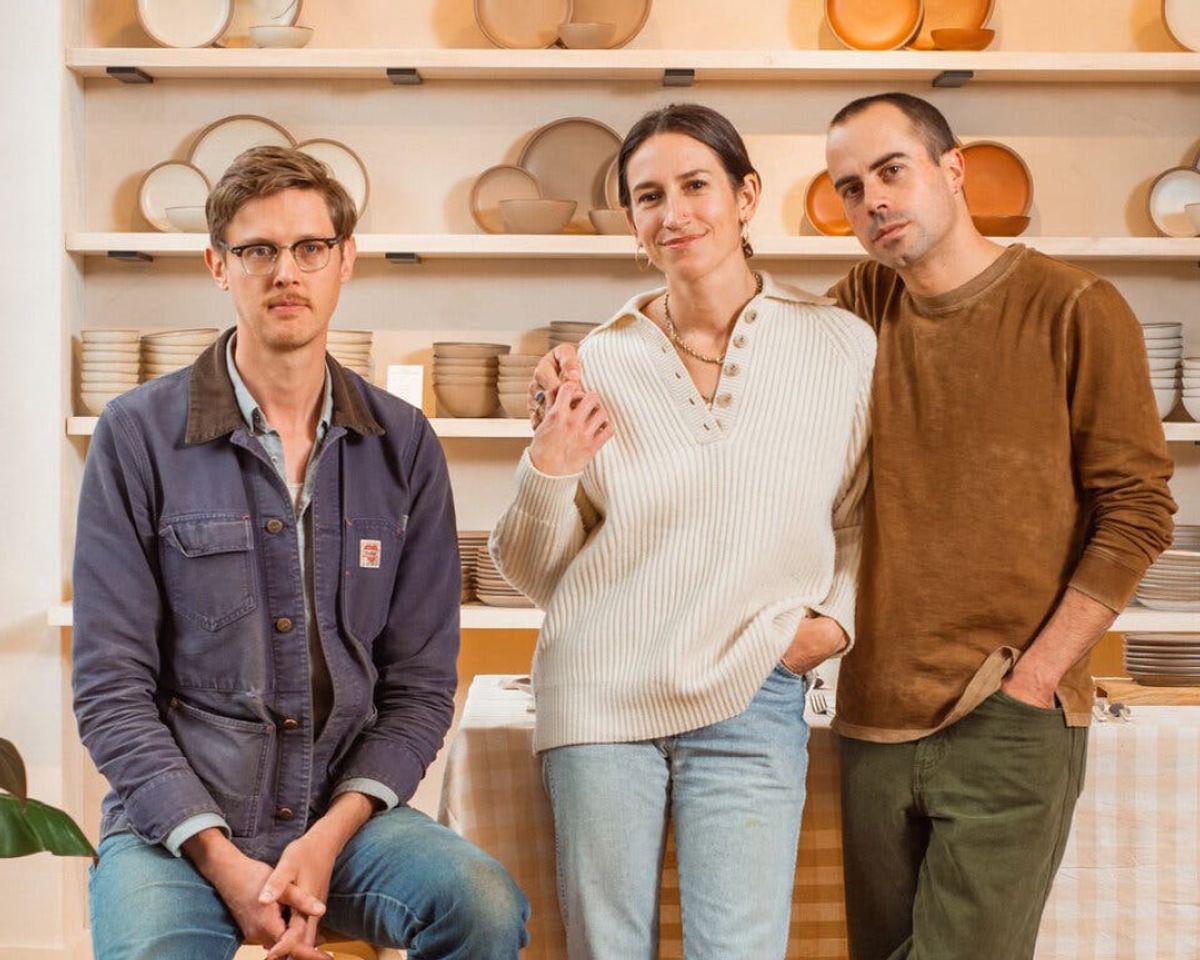 Alex Matisse, Connie Matisse, and John Vigeland in front of the dinnerware sets wall at the East Fork Asheville store.