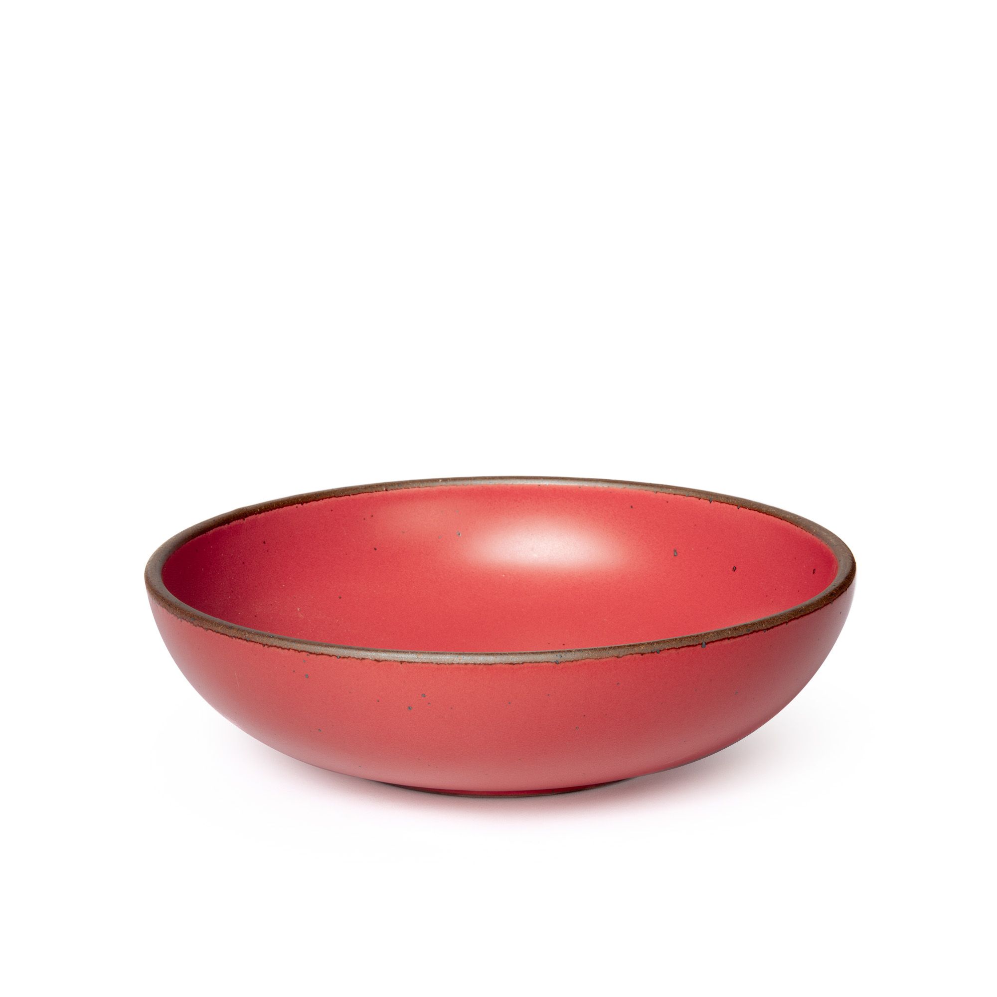 A large shallow serving ceramic bowl in a bold red color featuring iron speckles and an unglazed rim.