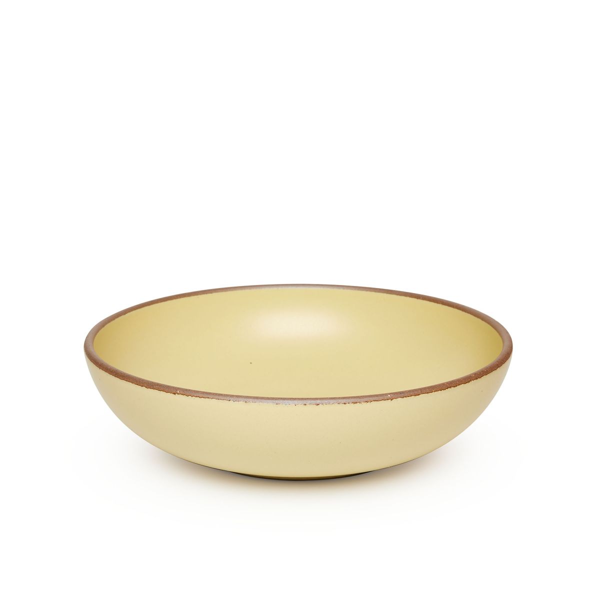 A large shallow serving ceramic bowl in a light butter yellow color featuring iron speckles and an unglazed rim