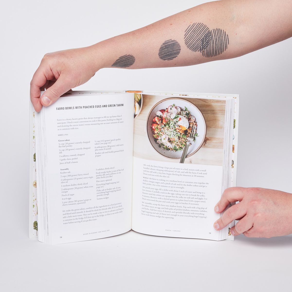 hands holding cookbook open on a recipe