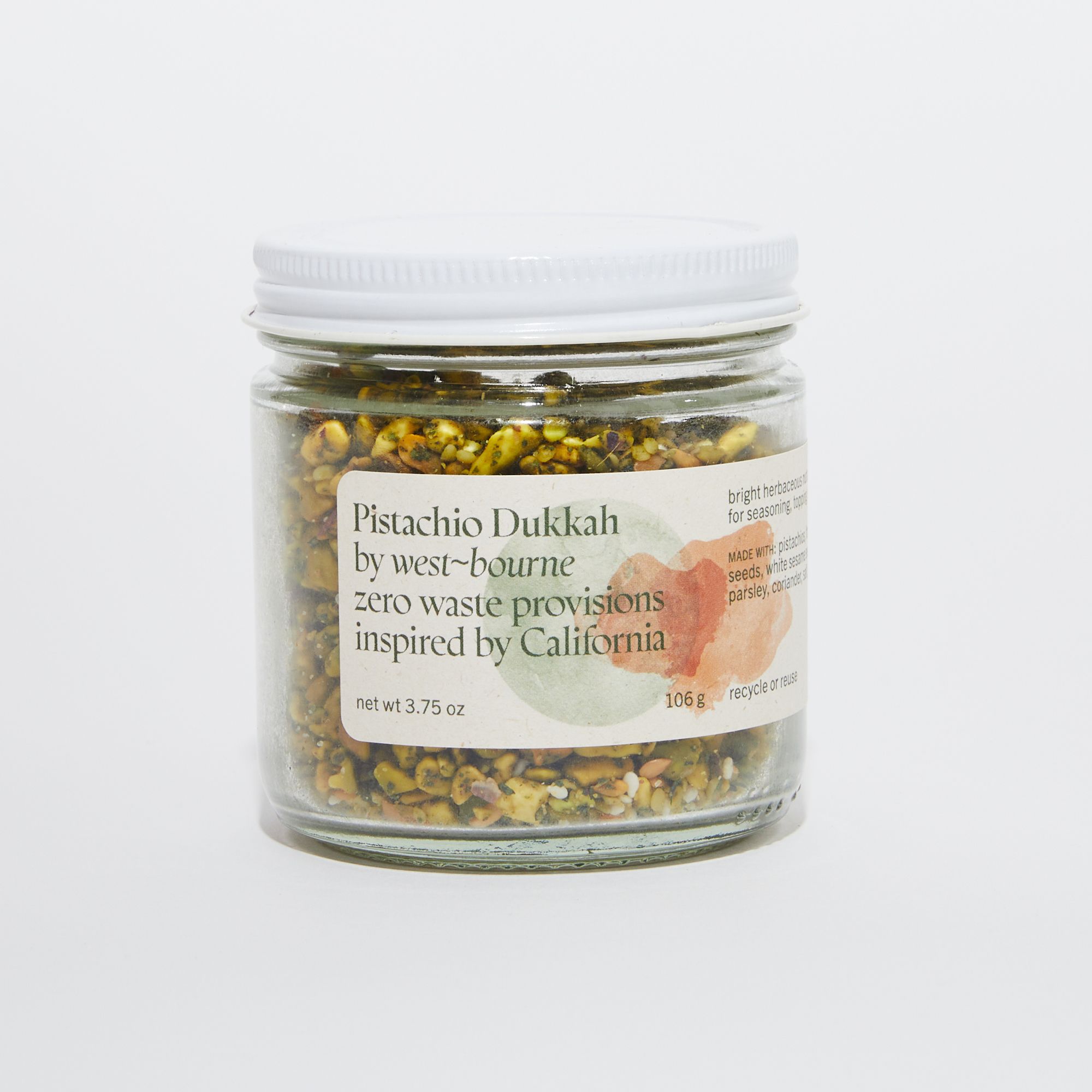 Clear jar of dukkah with a white lid and a label that reads "Pistachio Dukkah by west-bourne zero waste provisions inspired by California"