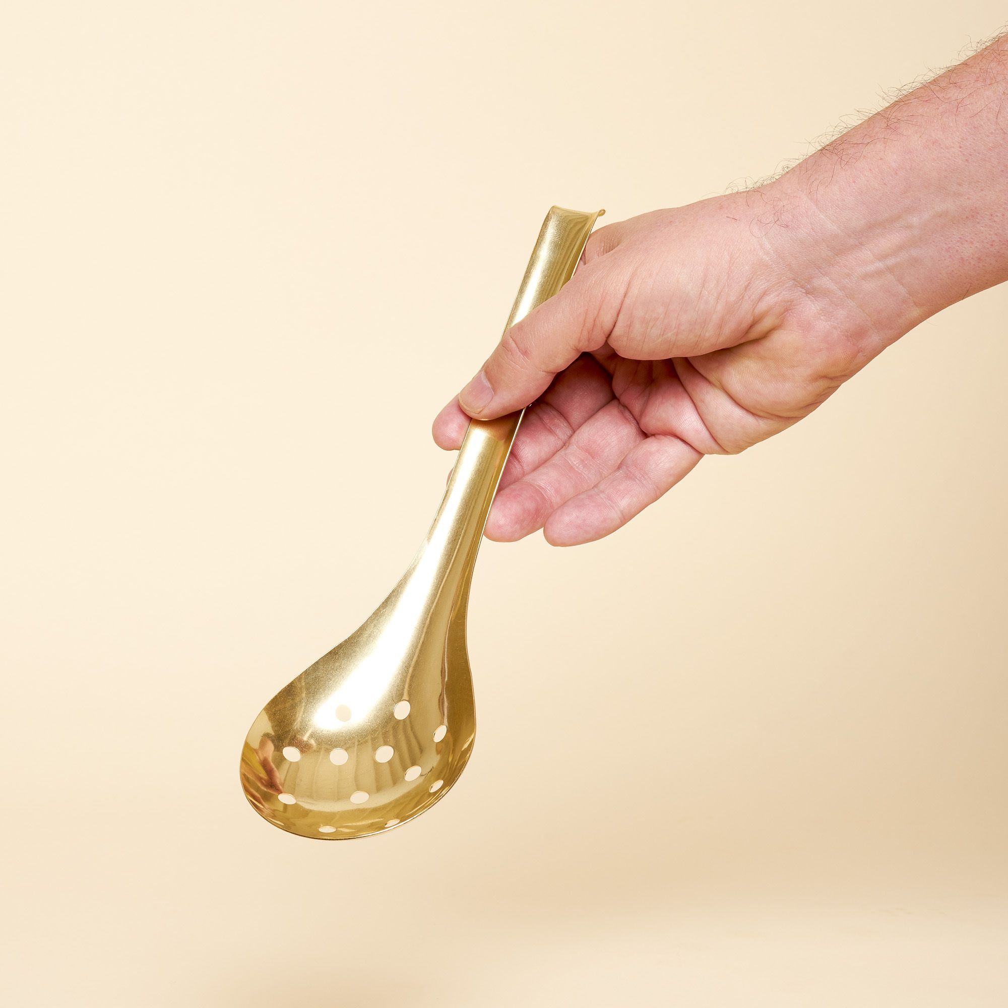 A brass ladle with a round circular bottom. Comes in solid brass or slated with small holes that allows liquid to pass through.