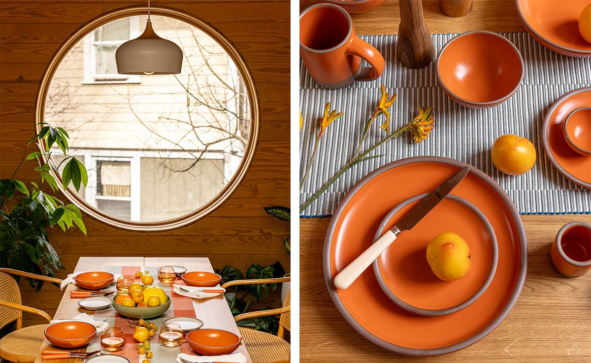 Two photos featuring table set with a table runner, bold orange bowls and plates, orange-handled flatware, whiskey snifters, and a centerpiece of fruits and vegetables. Also pictured is a woven chairs at the table table, a large houseplant, and a large circular window.