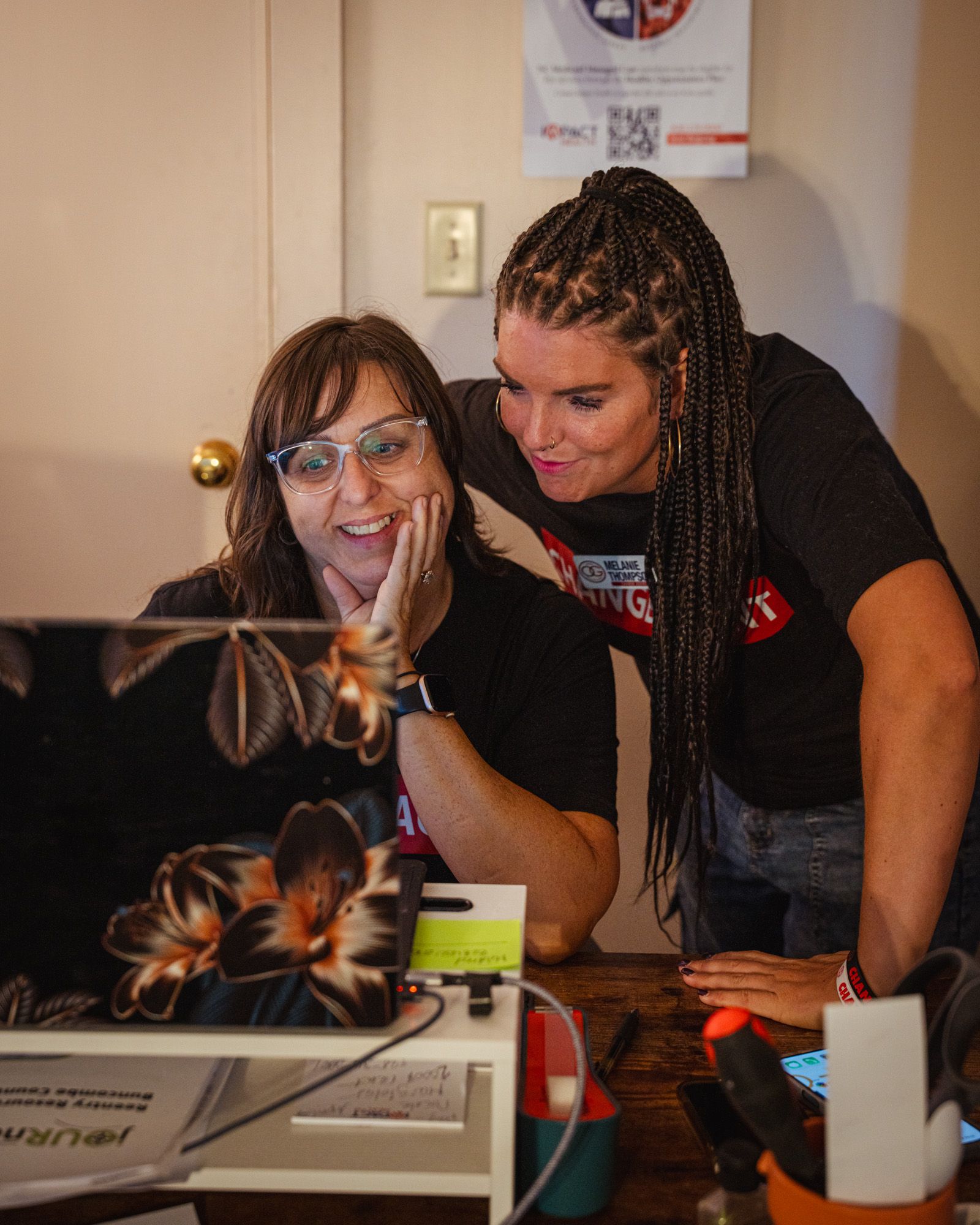 Two people are working together at the Operation Gateway office staring at a computer.