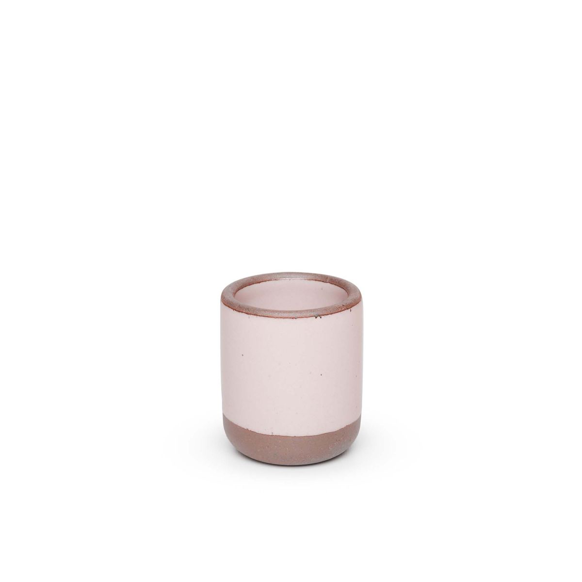 A small, short ceramic mug cup in a soft light pink color featuring iron speckles and unglazed rim and bottom base