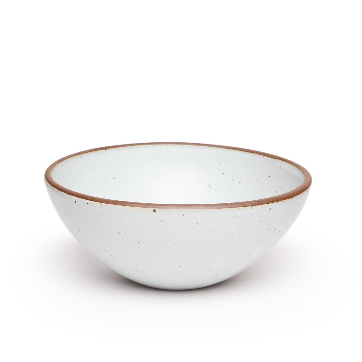 A large ceramic mixing bowl in a cool white color featuring iron speckles and an unglazed rim