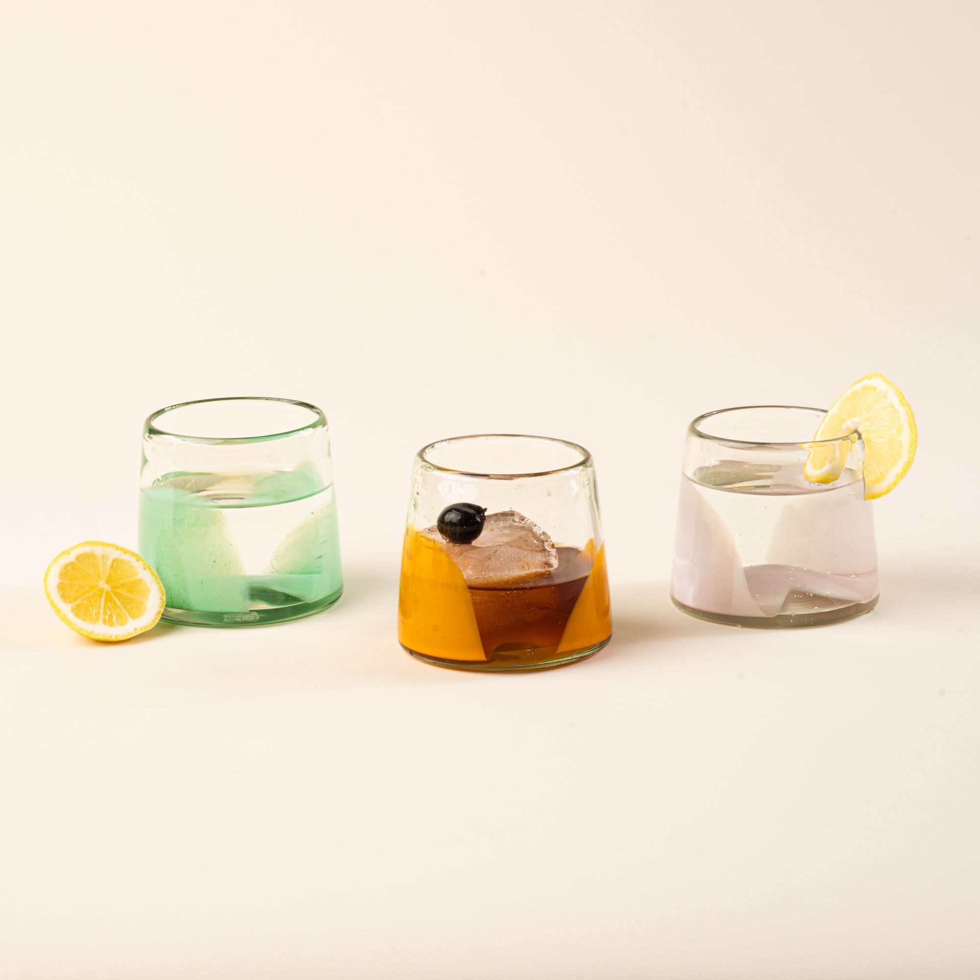 olorful glass tumblers scattered with fruit and flowers casting patterned light shadows.