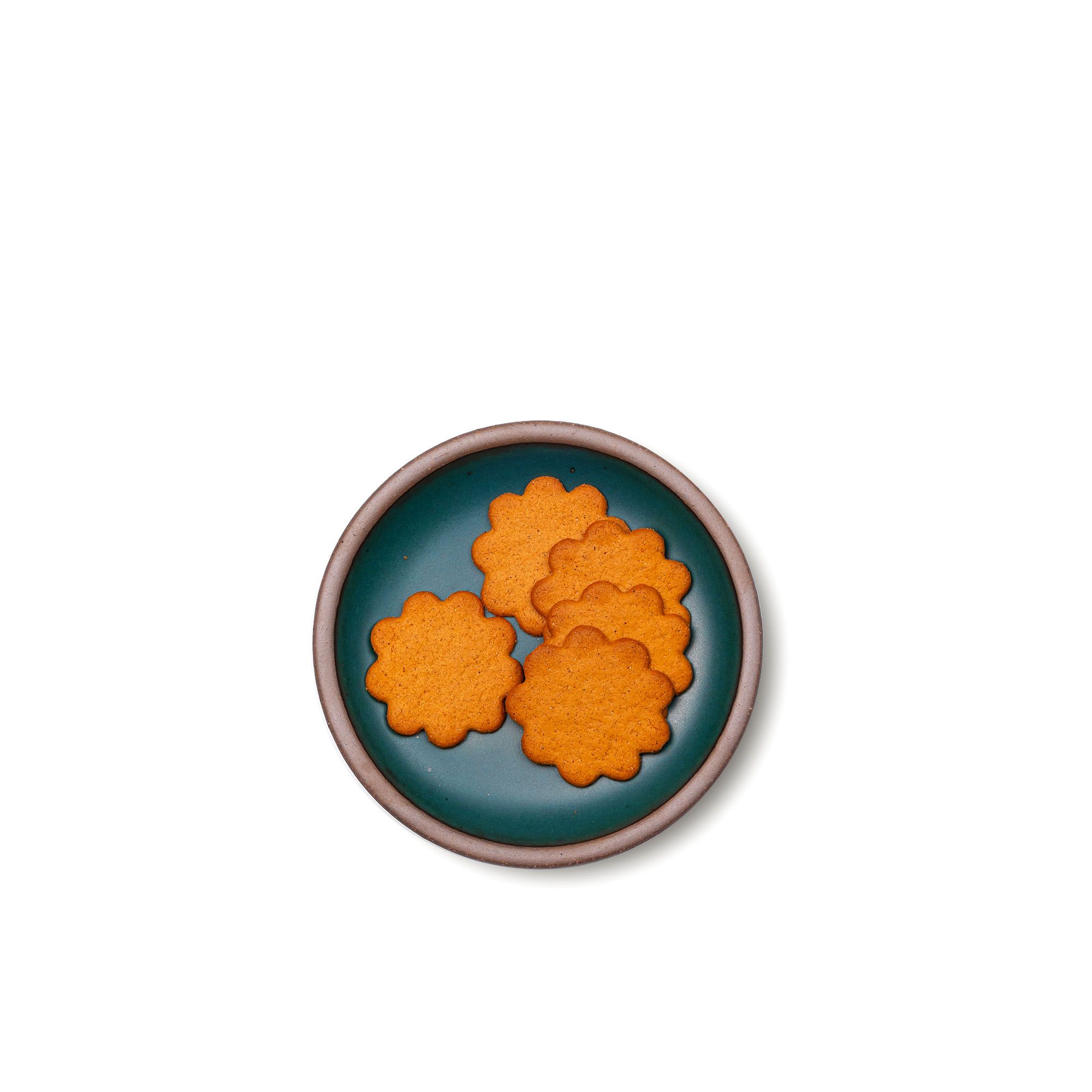 Cookies on a dessert sized ceramic plate in a deep dark teal color featuring iron speckles and an unglazed rim