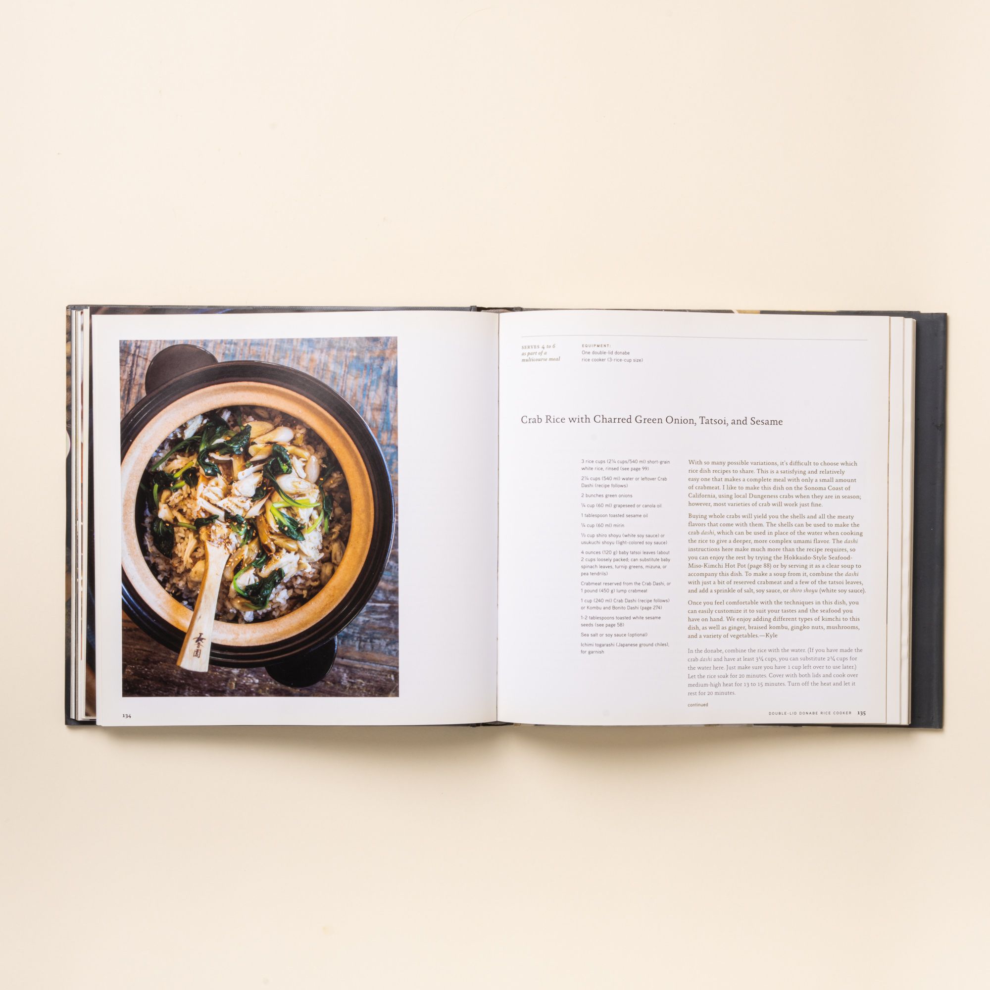 Open cookbook featuring a crab rice recipe, with a photo of a steaming donabe pot on the left page.