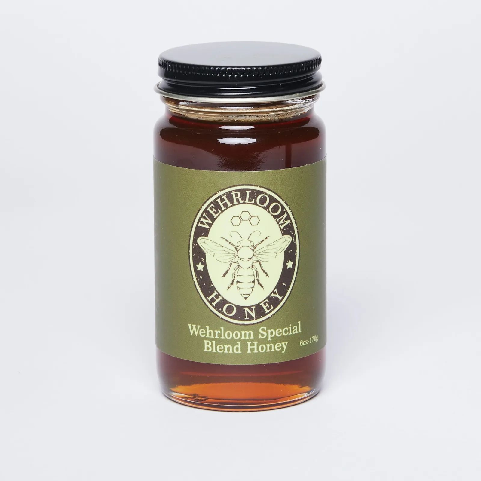 A jar of honey with a green label with a honeybee illustration 