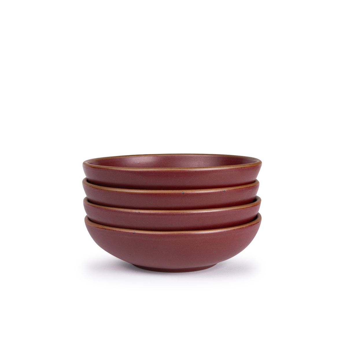 A stack of 4 dinner-sized shallow ceramic bowls in a plum color featuring iron speckles and an unglazed rim