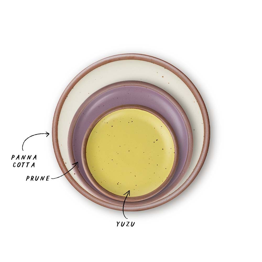 A stack of 3 plates in Dinner, Side, and Cake sizes in a warm off-white, soft mauve purple, and zesty yellow colors.