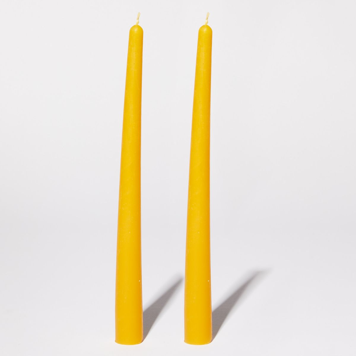 two yellow beeswax taper candles
