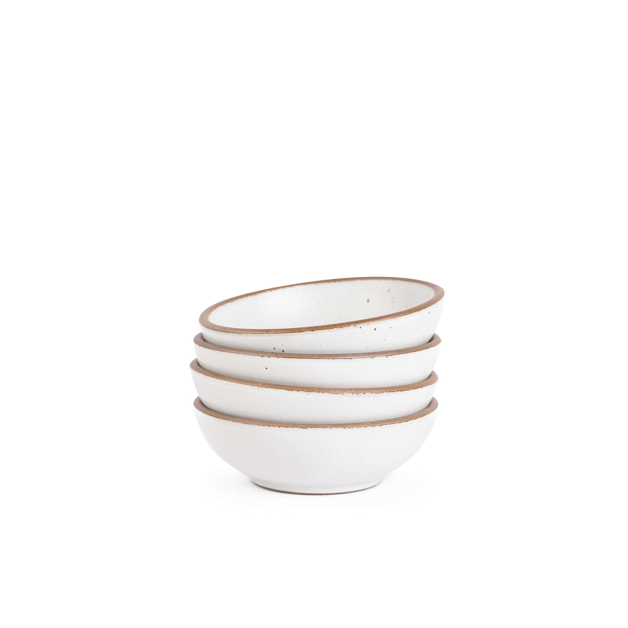 A stack of 4 small shallow ceramic bowls in a cool white color featuring iron speckles and an unglazed rim