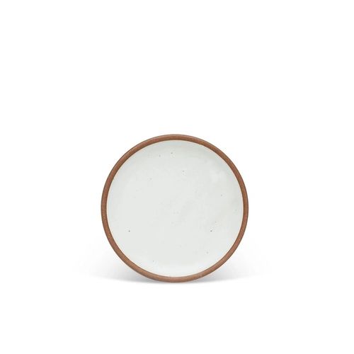 A dessert sized ceramic plate in a cool white color featuring iron speckles and an unglazed rim.