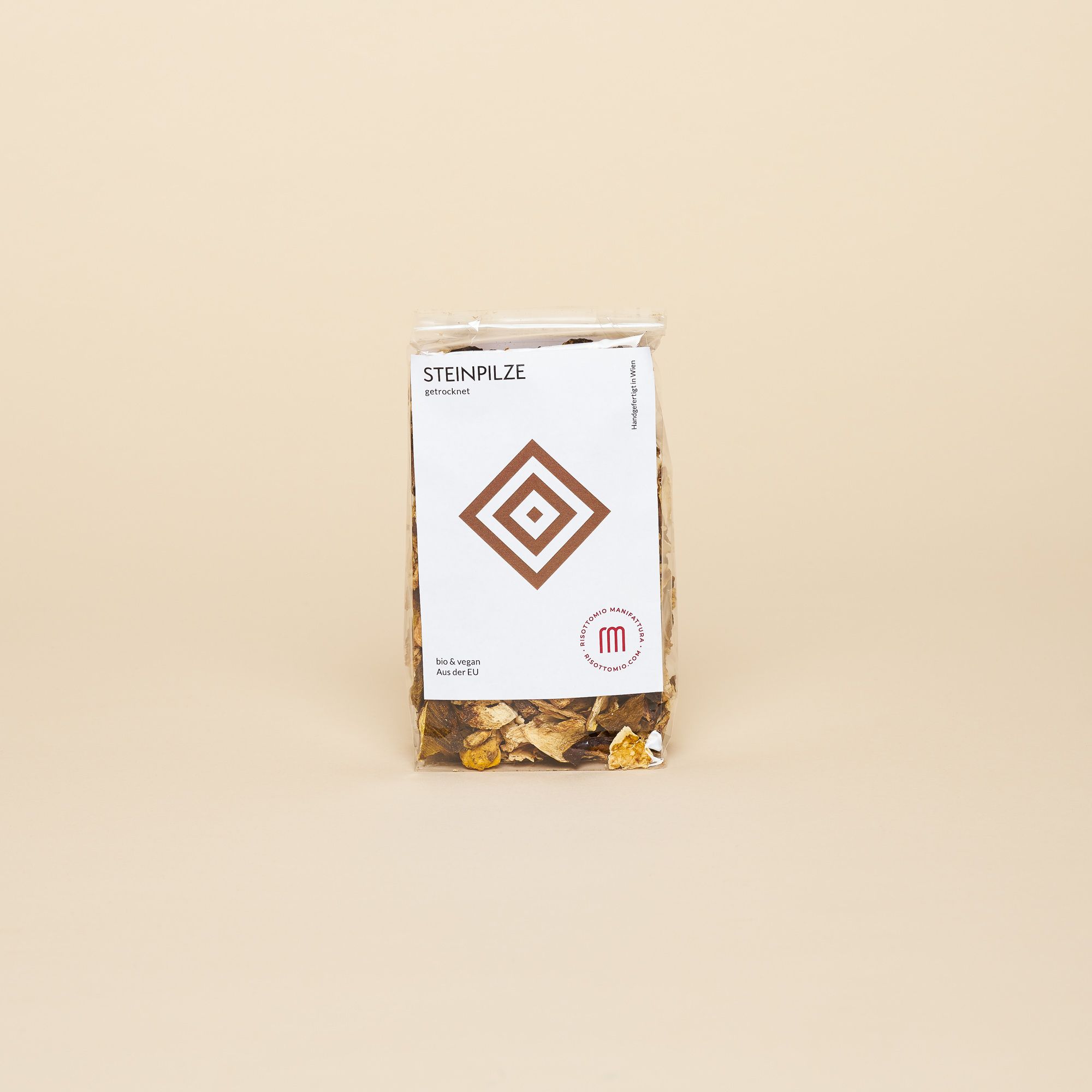 A clear bag with a large white label with a clean, modern Italian label. Inside, dried porcini mushrooms.