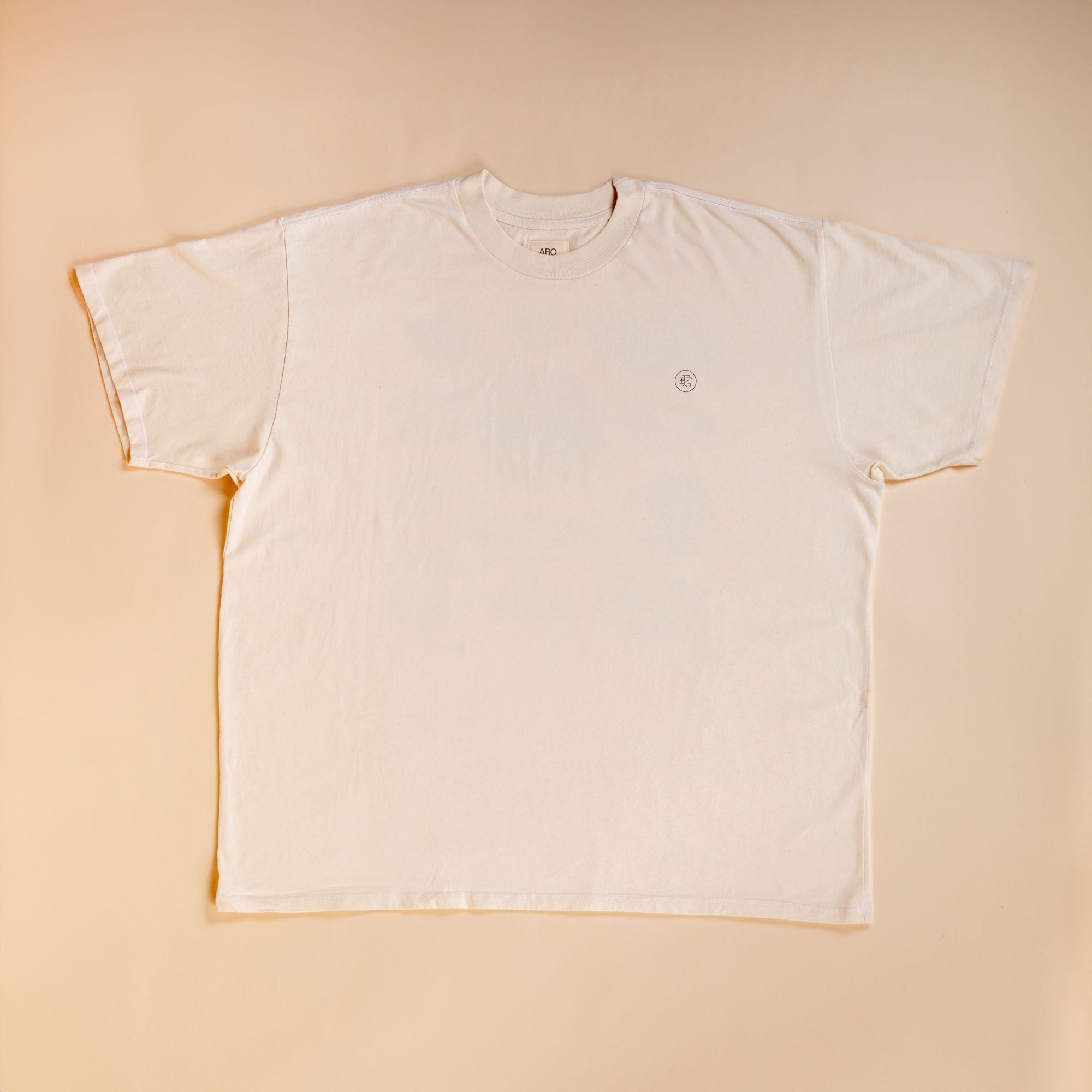 Flat lay t-shirt in cream against a cream background.  On the top right corner of the tee is a little 'East Fork' EF Logo.