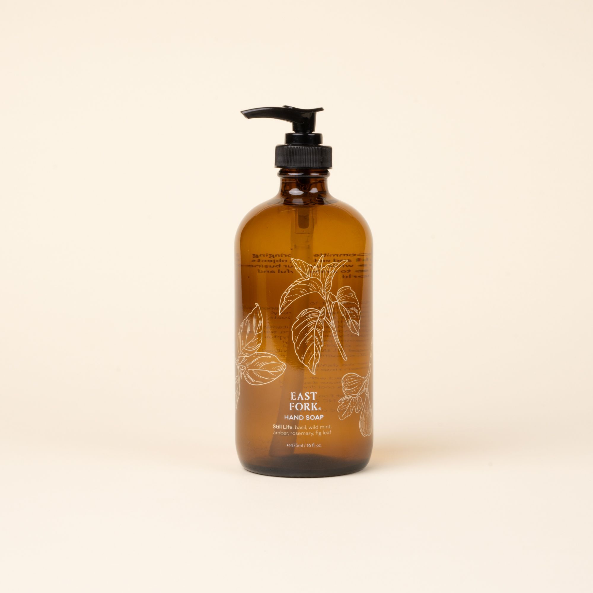 Amber glass pump bottle of East Fork hand soap with floral illustration, centered against a light neutral background.