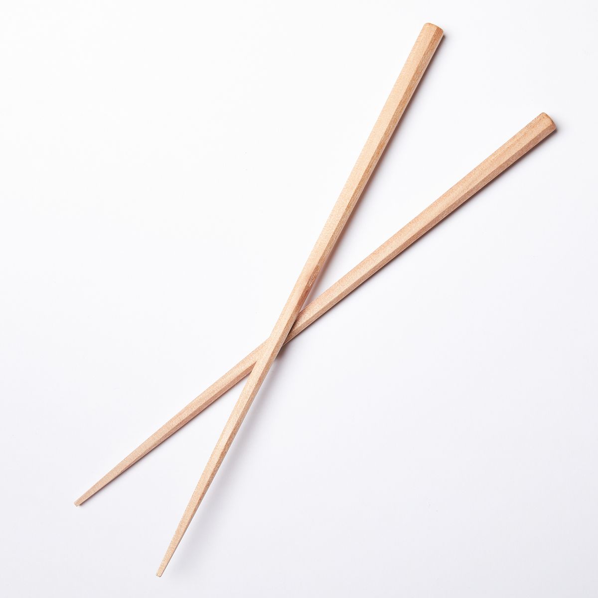 Simple pair of light wood chopsticks stacked over each other