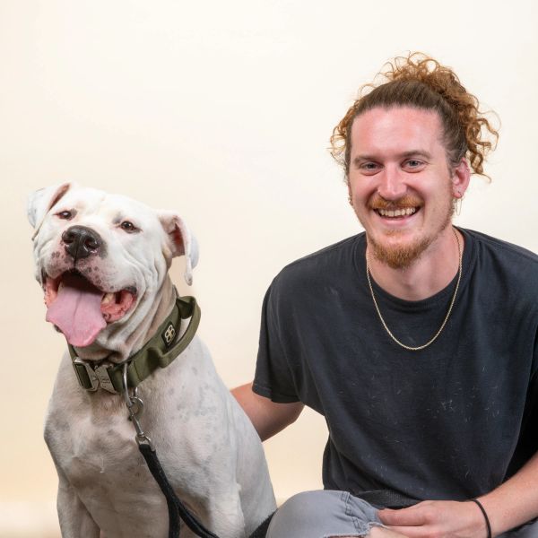 A headshot of Kevin J. with his large dog next to him