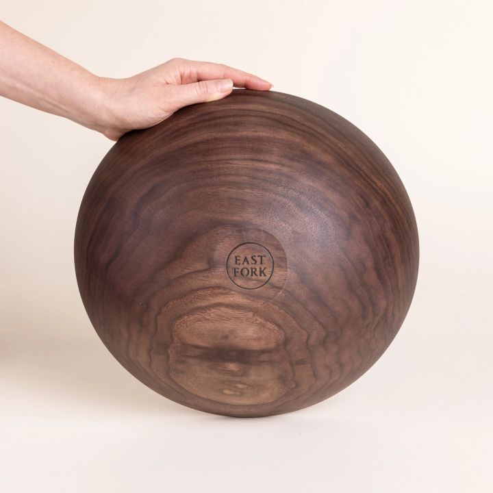 The bottom of a large walnut wood bowl with a stamp that reads "East Fork"