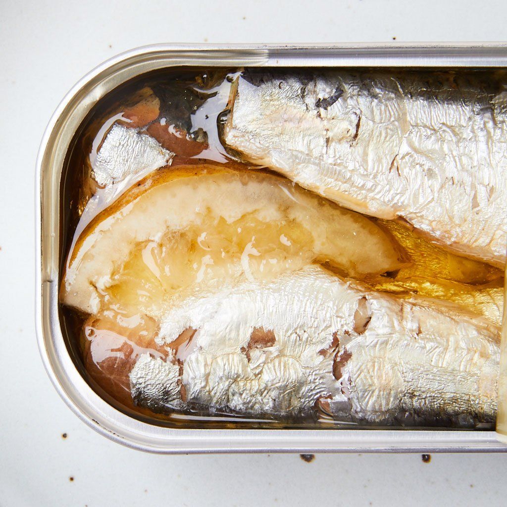 Closeup of open tin of sardines in olive oil