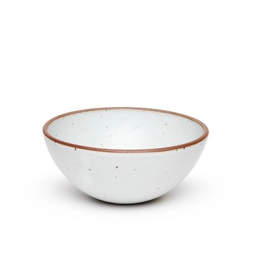 A large rounded ceramic bowl in a cool white color featuring iron speckles and an unglazed rim