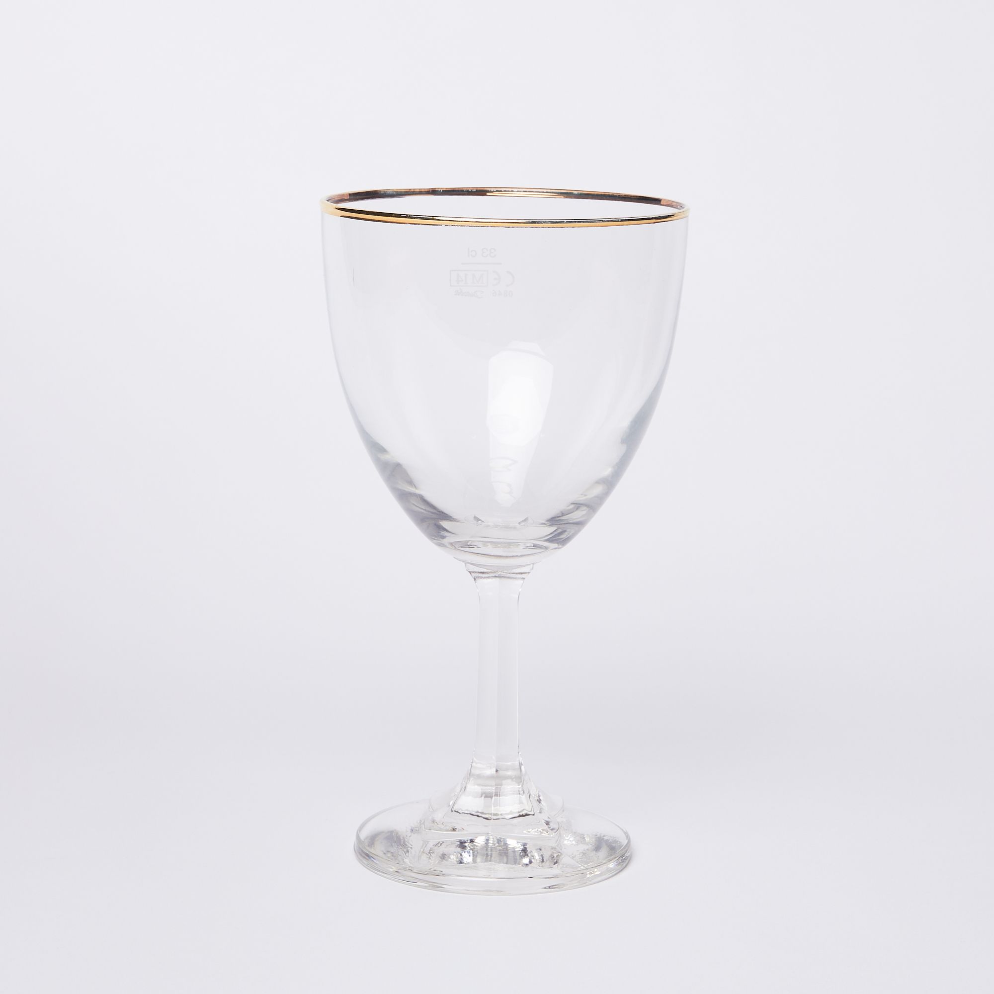 A stemmed clear beer glass with a gold rim on a white background
