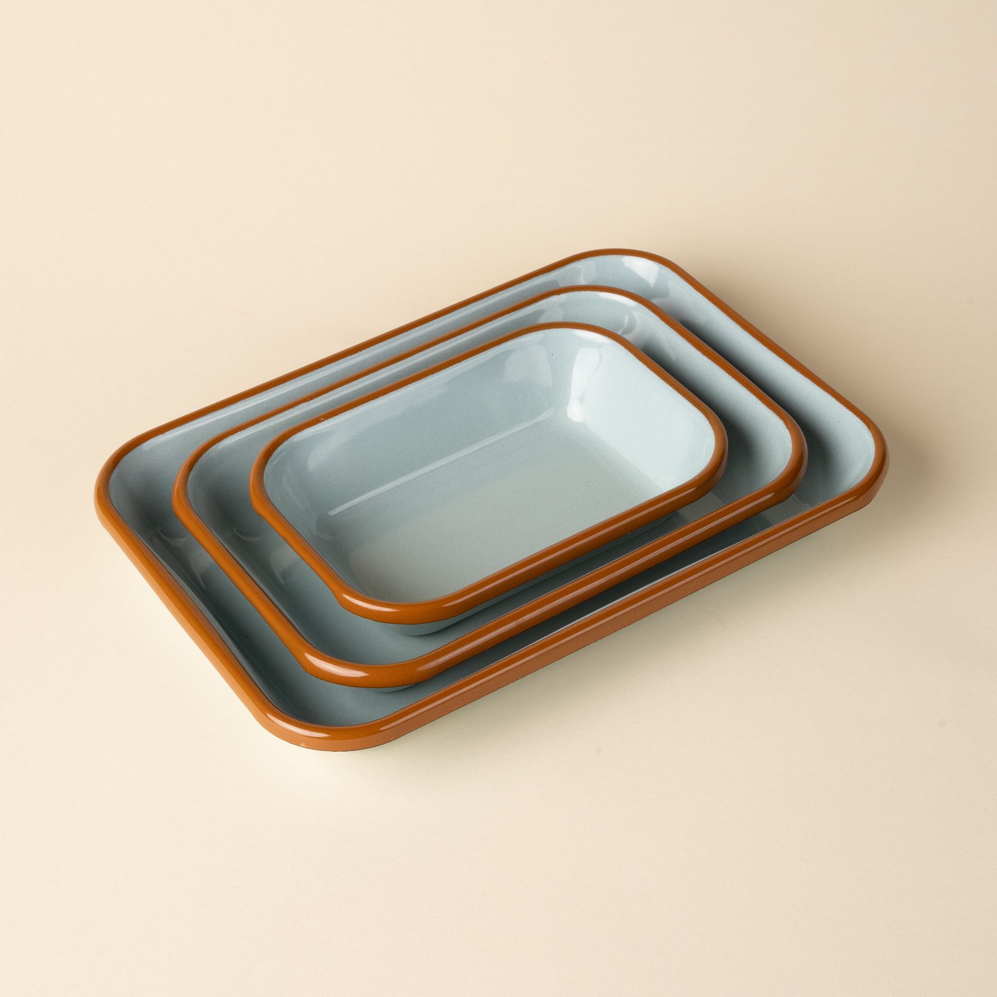 A nesting trio of small, medium, and large rectangular baking dishes in a robin's egg blue color with a warm brown rim.