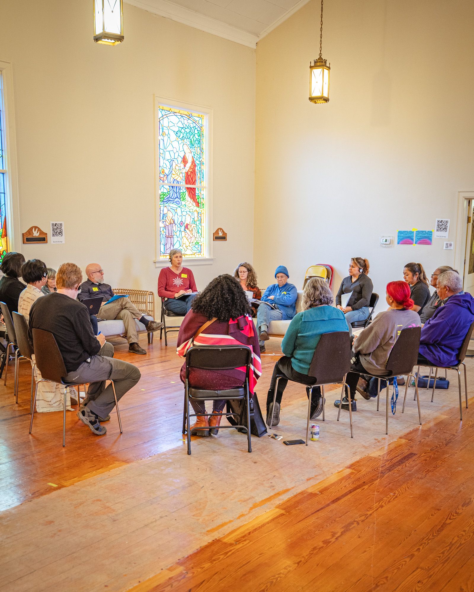 A diverse group of people gathered in a circle in the middle of conversation.