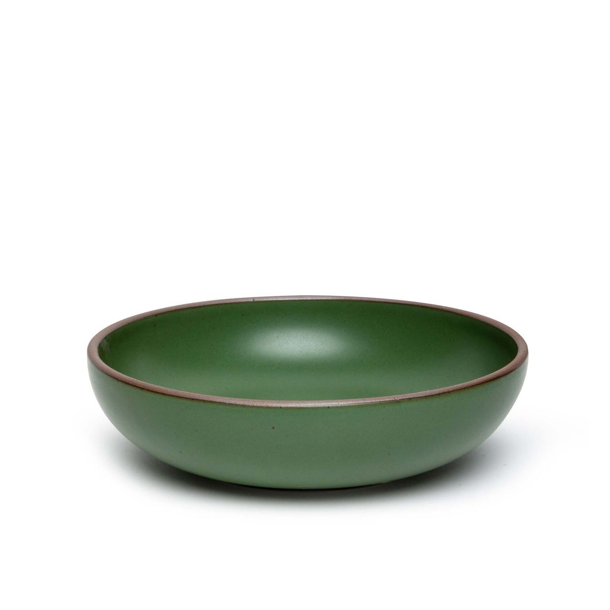 A large shallow serving ceramic bowl in a deep, verdant green color featuring iron speckles and an unglazed rim.