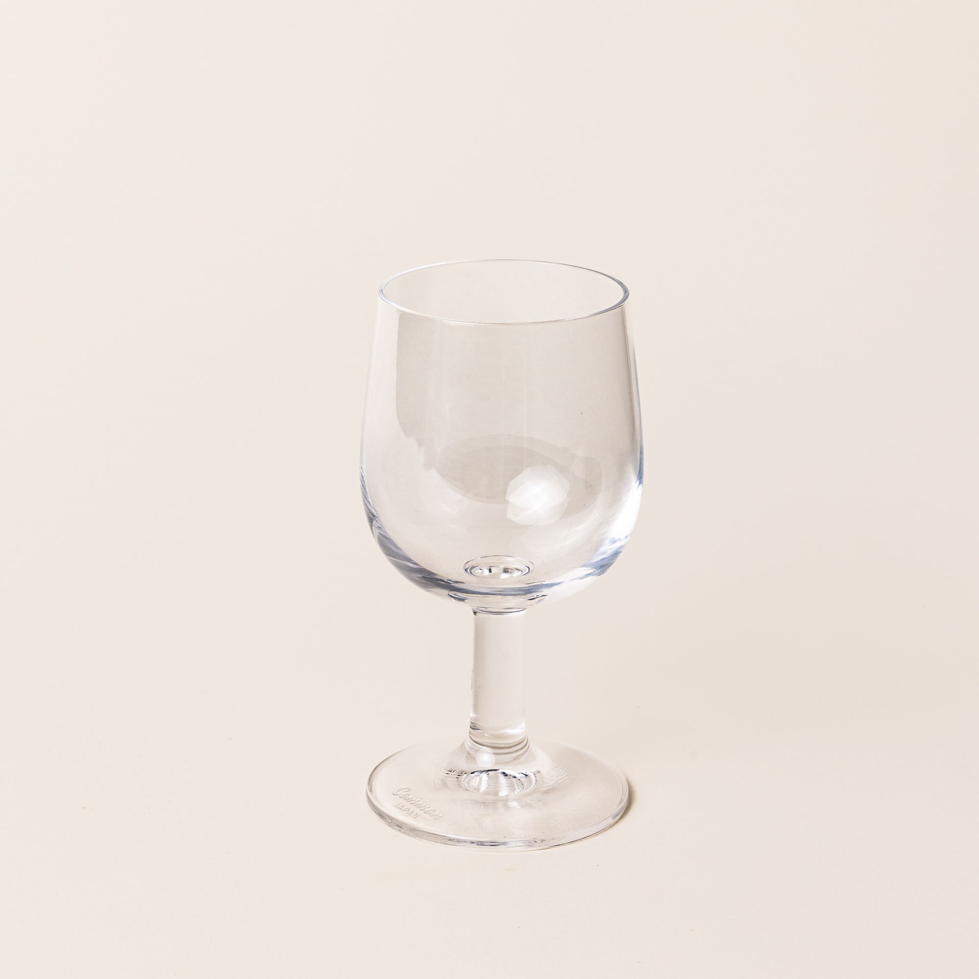A clear wine glass with a short stem and wide cup.