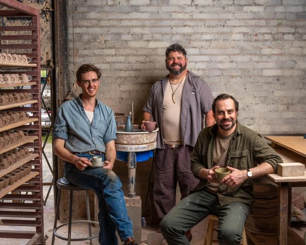 Alex, Mike and John smiling and holding workshop mugs and espresso cups in East Fork Workshop.