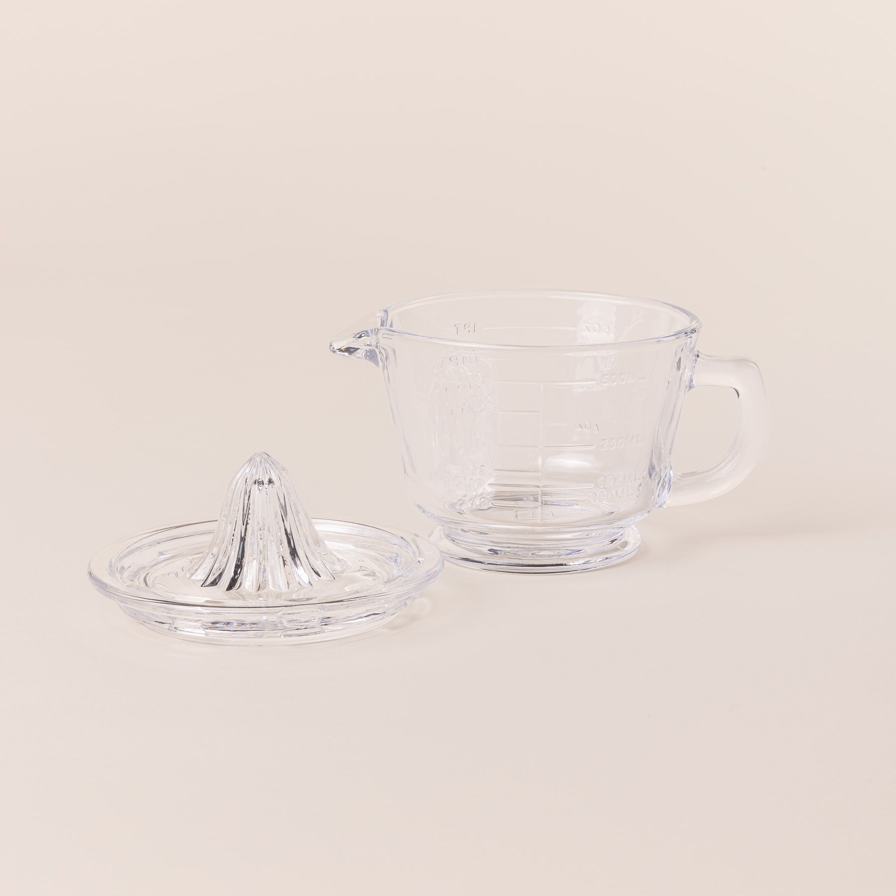 Traditional glass juicer with a handle and removable top off to the side