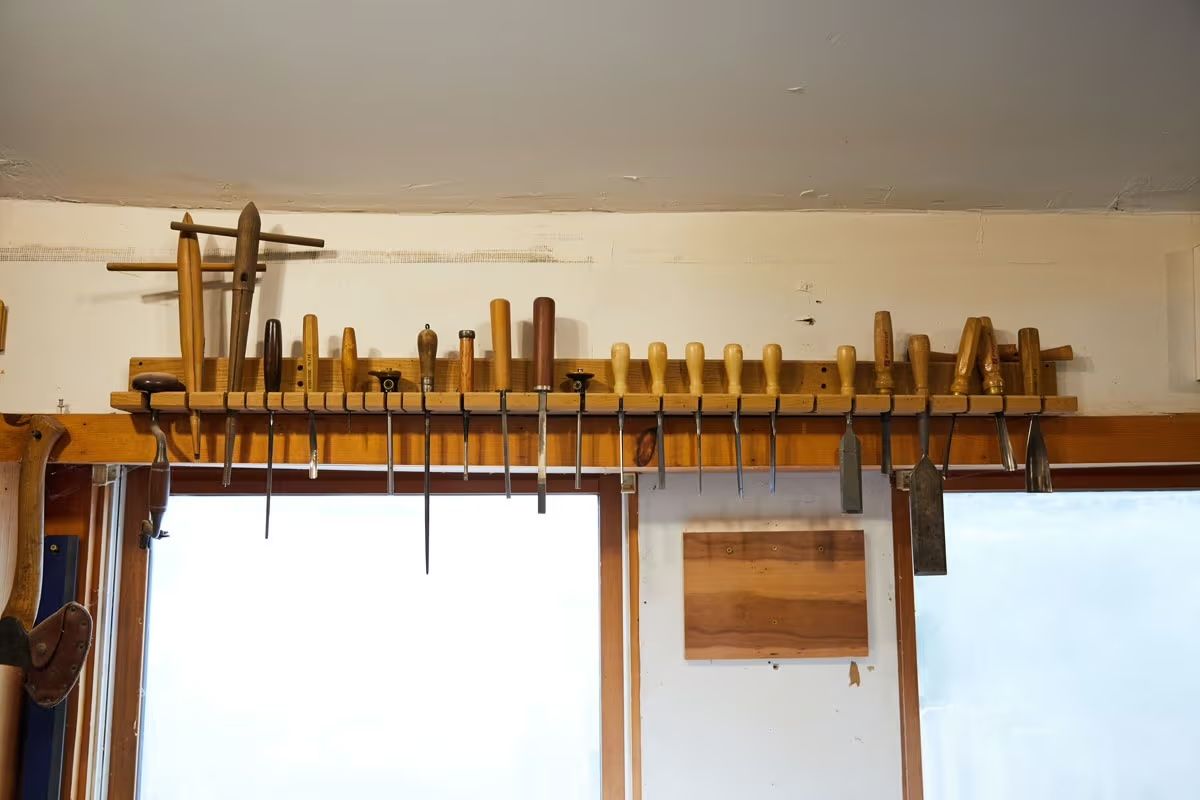 Several wood tools hanging on a wall in a wood workshop