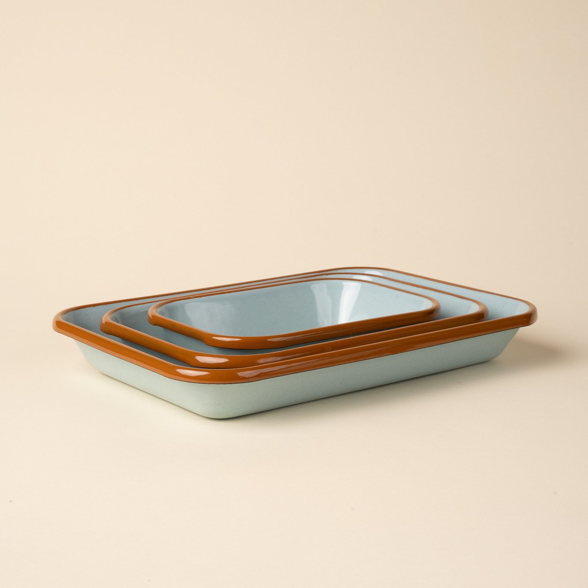 A nesting trio of small, medium, and large rectangular baking dishes in a robin's egg blue color with a warm brown rim.