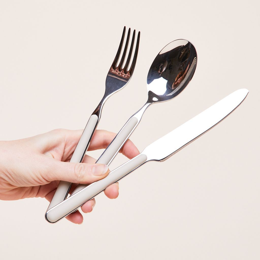 There are three pieces of flatware held in a hand