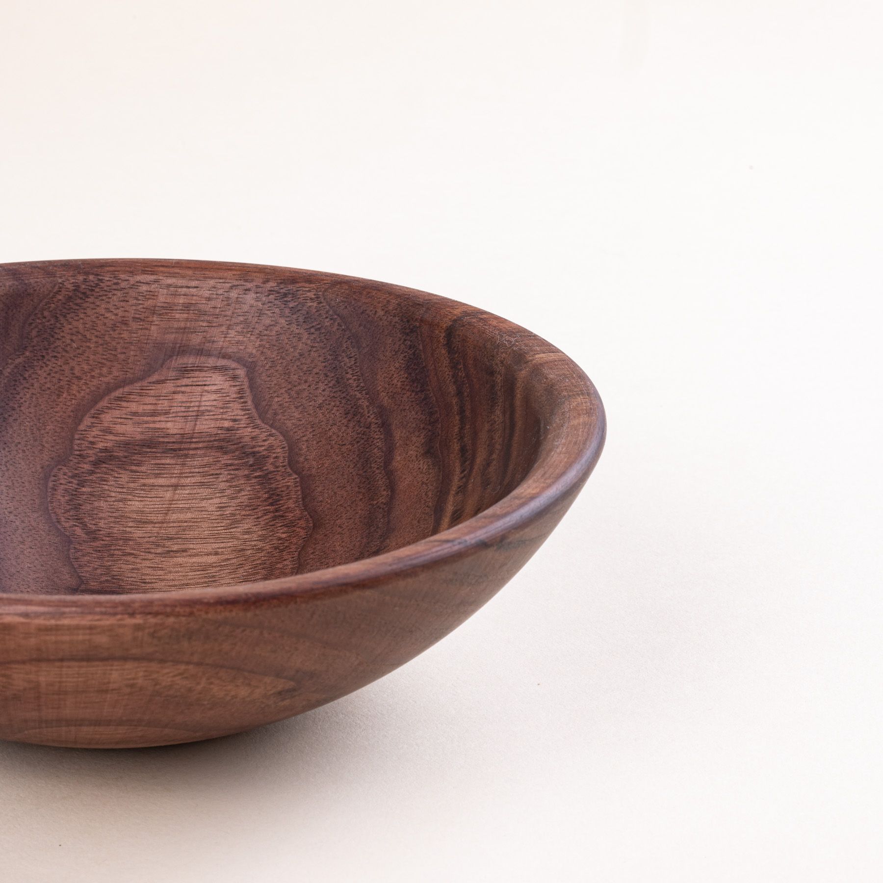 A closeup of the edge of a walnut wood bowl