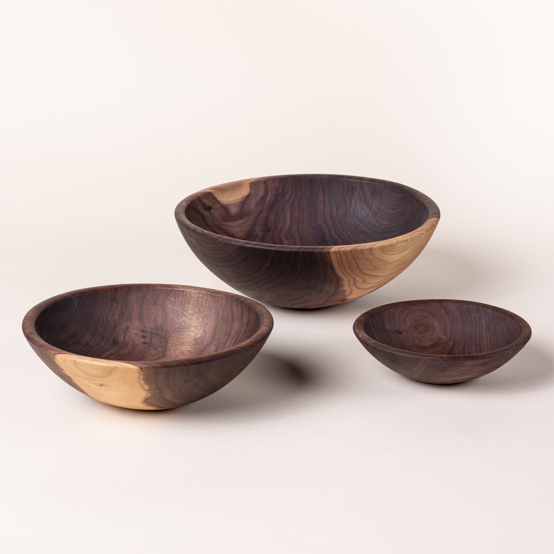 3 round walnut bowls in small, medium, and large sizes.