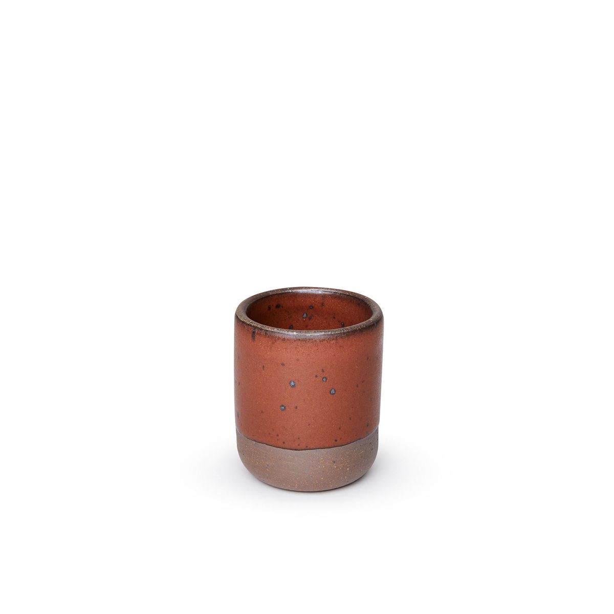 A small, short ceramic mug cup in a cool burnt terracotta color featuring iron speckles and unglazed rim and bottom base.